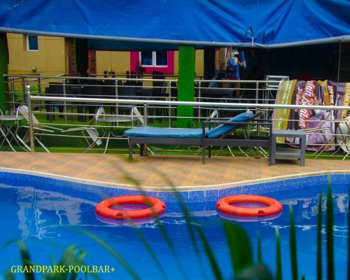 a pool with three red frisbees next to a slide at GRAND PARK HOTEL AND SUITEs in Egbe