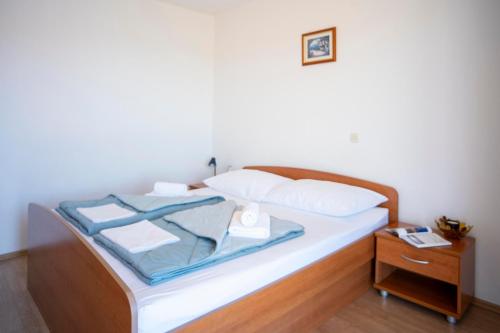 a bed with white pillows and a nightstand next to it at Villa MAR in Orebić
