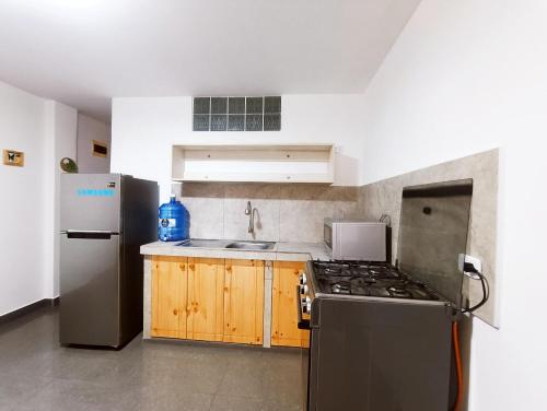 une cuisine avec une cuisinière et un réfrigérateur dans l'établissement Quédate con Miranda, à Punta Hermosa