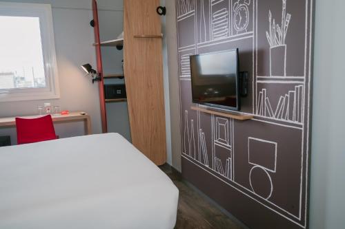 a room with a bed and a tv on a wall at ibis Trujillo in Trujillo