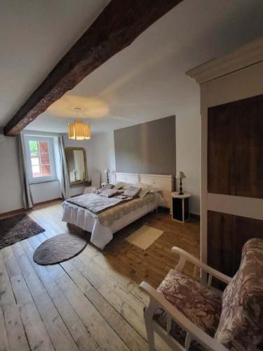 - une grande chambre avec un lit et une chaise dans l'établissement Domaine de LOLI, à Saint-Girons