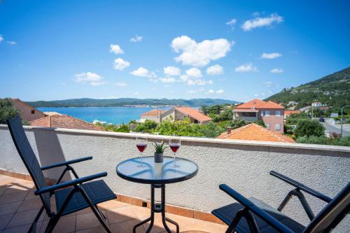 a balcony with a table and two glasses of wine at Villa MAR in Orebić