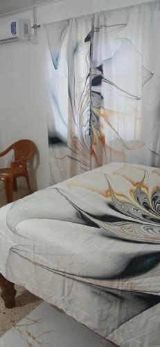 a bed with a white comforter and a pillow at Entire 3 bedroom house in St Thomas, Jamaica in Port Morant