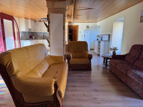 un salon avec un canapé et deux chaises dans l'établissement Gîte de Lendrevie, à Proissans