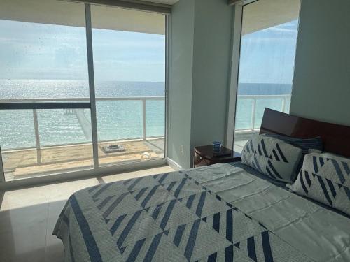 a bedroom with a bed and a view of the ocean at Luxurious 2BD Condo with Direct Ocean Front & Resort Pool in Sunny Isles in Sunny Isles