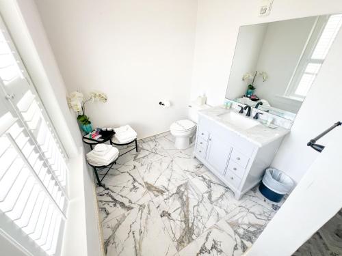 a white bathroom with a sink and a mirror at Artisan Downtown in DeLand