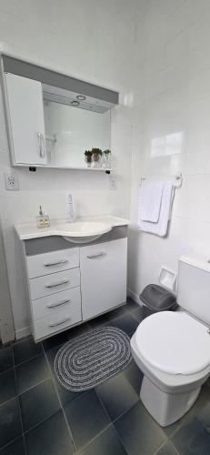 a white bathroom with a toilet and a sink at Alpen Haus - Ideal para família e grupo in Santa Rosa
