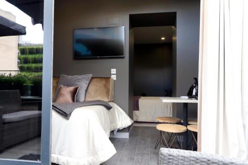 a bedroom with a bed and a tv on the wall at Charm Flats in Lisbon