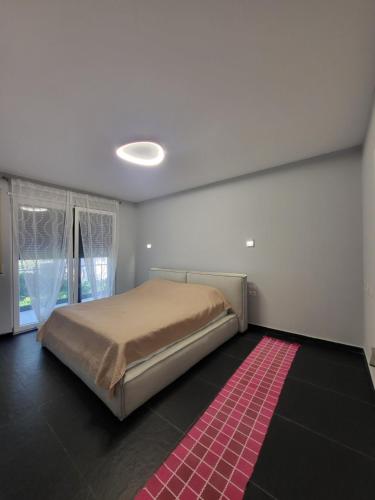 a bedroom with a bed and a red rug at Peonia Villa ValaMar in Draç