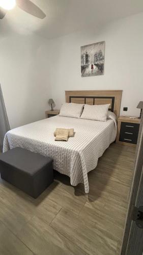 a bedroom with a large white bed with a ottoman at Casa Filo, maravilloso apartamento en Morro Jable in Morro del Jable