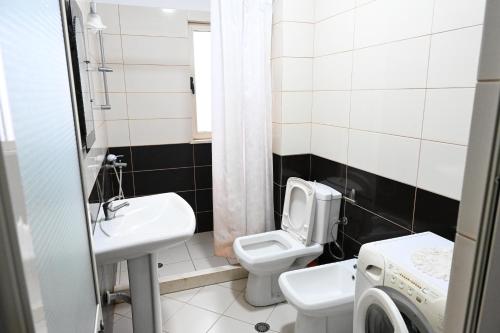 a small bathroom with a toilet and a sink at Beach Apartments - Shengjin in Shëngjin