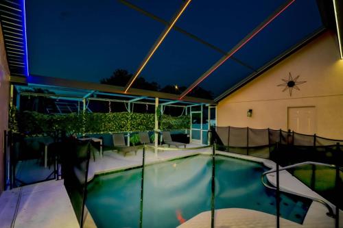 a swimming pool in the middle of a building at night at Themed house with private Game Room and Pool in Loughman