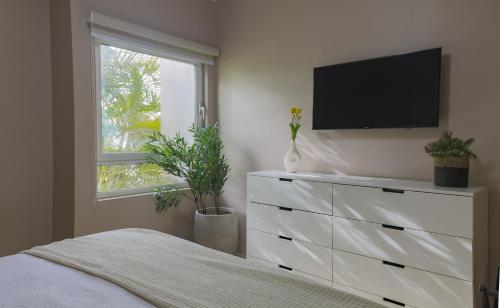 パーム・イーグル・ビーチにあるModern Ground Level Condo, 2 bedrooms, Direct pool accessのベッドルーム(テレビ付きドレッサー付)