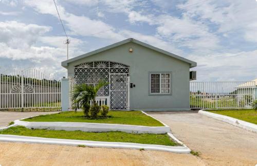 a small house with a gate in front of a fence at CrearyStays in Discovery Bay