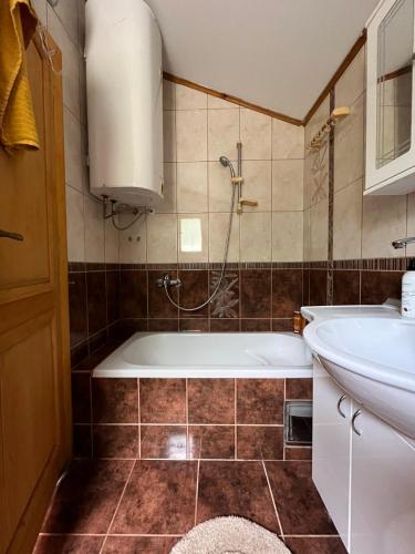 a bathroom with a tub and a sink at Kota 1120 in Mojkovac