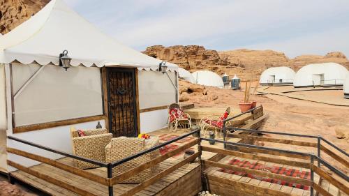 a tent with chairs and tables in the desert at Rum rose luxury camp in Wadi Rum