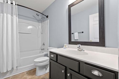a bathroom with a sink and a toilet and a mirror at Blue Belle - Across from Pool near Credit One in Charleston