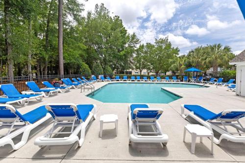 a swimming pool with blue and white lounge chairs at Blue Belle - Across from Pool near Credit One in Charleston