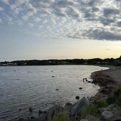two people standing in the water on a beach at 047 Farmhouse - Nevlunghavn in Lii