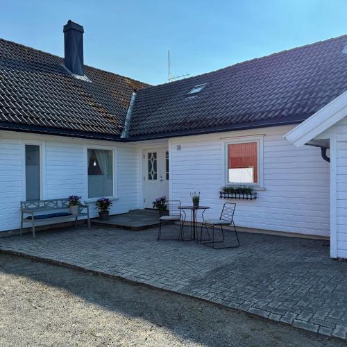 a white house with a patio with chairs and a table at 047 Farmhouse - Nevlunghavn in Lii