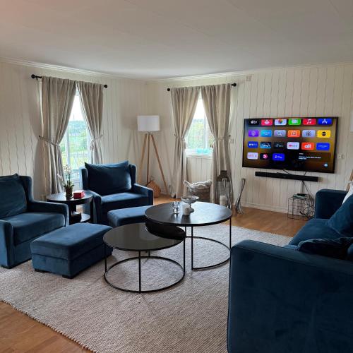 a living room with blue furniture and a flat screen tv at 047 Farmhouse - Nevlunghavn in Lii