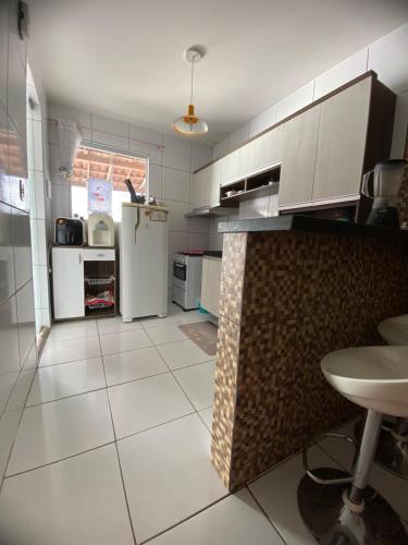 a kitchen with white appliances and a white tile floor at Casa Bella Temporada in Campina Grande