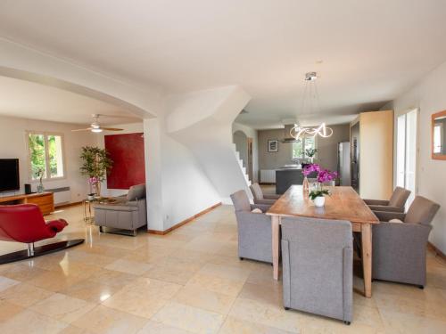 a dining room and living room with a table and chairs at Belle vue in Le Flayosquet