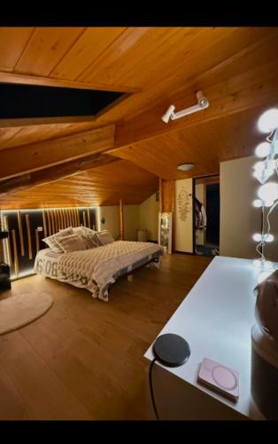 une chambre avec un lit et un plafond en bois dans l'établissement Cosy Maison Familiales, à La Llagonne
