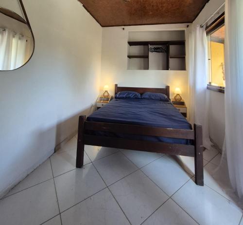 una camera con un letto in una stanza con due lampade di Apartamento centro a Búzios