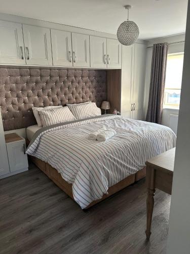 a bedroom with a large bed with a large headboard at Dublin Modern 4-5 bedroom house in Dublin