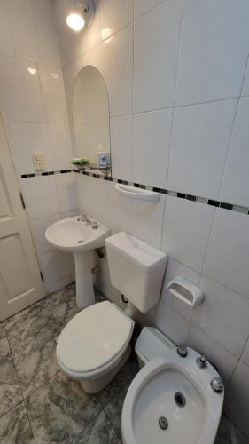 a white bathroom with a toilet and a sink at El Rincón del cactus in San Rafael