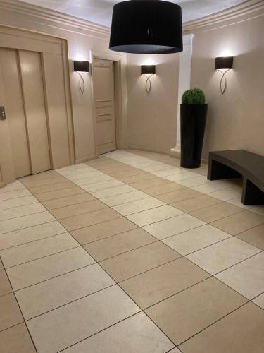 une grande pièce avec un sol carrelé avec une plante en pot dans l'établissement Superbe 2 pièces 55 m2 Juàn les pins, à Juan-les-Pins