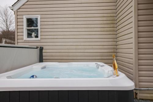 una gran bañera de hidromasaje junto a una casa en The Modern Escape - Hottub 3min To Pool & Lake, en Long Pond
