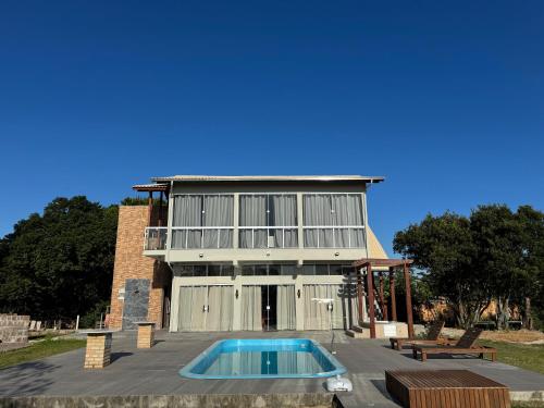 une maison avec une piscine devant dans l'établissement Apartamento de frente para lagoa -Ap 101, à Laguna