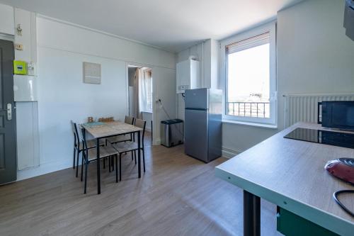 Il comprend une cuisine équipée d'une table et d'un réfrigérateur. dans l'établissement Elodie - Cosy 5 pers' - Gare - Wifi - 3 lits, à Homécourt