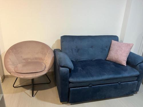 a blue couch with a pink pillow and a chair at PAIPA Hermoso apartamento en RUSTICO 709 in Paipa