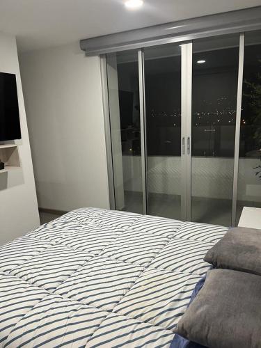 a bedroom with a bed with a view of the city at PAIPA Hermoso apartamento en RUSTICO 709 in Paipa