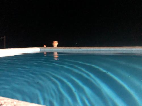 un hombre sentado en una piscina por la noche en La viña bonita, en Gallegos de San Vicente