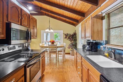 a kitchen with wooden cabinets and a dining room at Mountain Chalet with hot tub ! in Gatlinburg