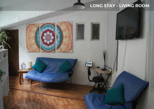 a living room with two blue couches and a television at Casa Sentidos in Mexico City