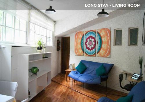 a living room with a blue couch in a living room at Casa Sentidos in Mexico City