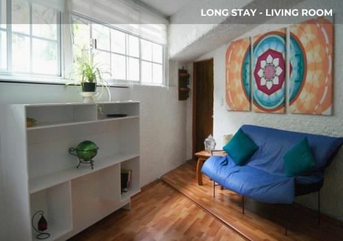 a living room with a blue couch in a room at Casa Sentidos in Mexico City