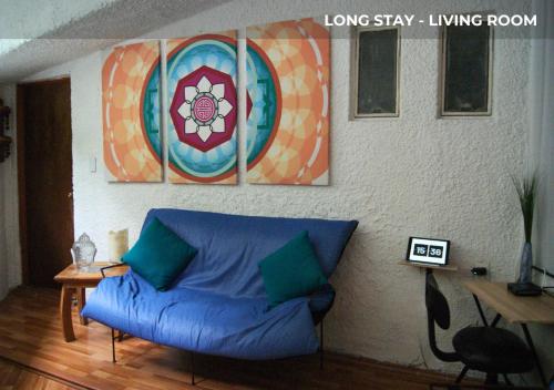a living room with a blue couch in front of a wall at Casa Sentidos in Mexico City