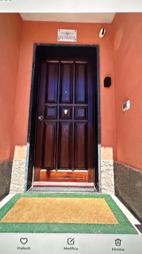 a wooden door on a orange building with a staircase at A Due Passi dal Mare in Catanzaro