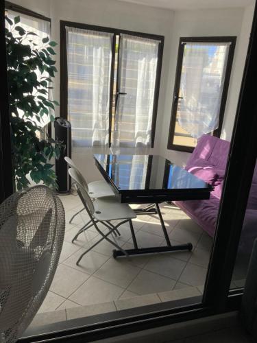 d'une table en verre et d'une chaise sur un balcon. dans l'établissement 2 pièces 55 m2 Juàn les pins, à Juan-les-Pins