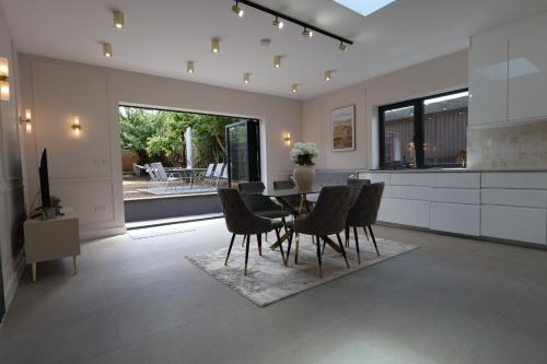 a kitchen and dining room with a table and chairs at Luxury House for Families and Contractors, NamisSuites Serviced Apartment - Farnborough in Farnborough