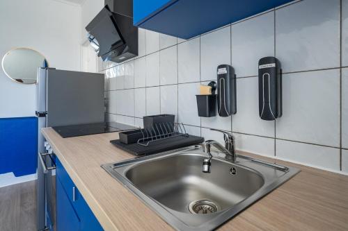 a kitchen with a stainless steel sink in a kitchen at Bleu Océane - Wifi - Gare - 3 lits - Tout équipé in Homécourt