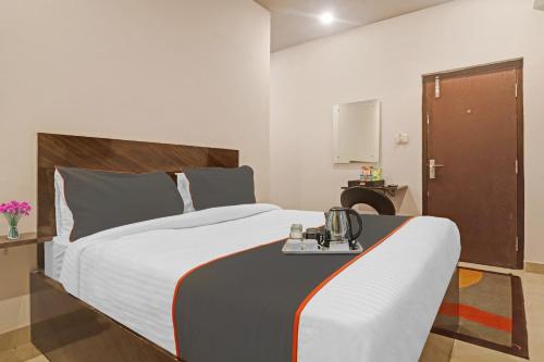a bedroom with a large bed with a phone on it at Super Townhouse RCC Pristine in Hyderabad