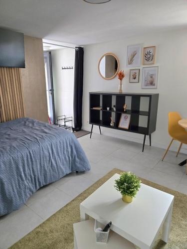 a bedroom with a large bed and a table at Grand studio cosy proche Paris in Épinay-sur-Seine