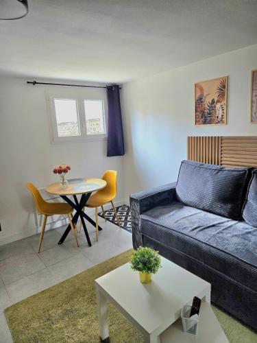 un salon avec un canapé et une table dans l'établissement Grand studio cosy proche Paris, à Épinay-sur-Seine